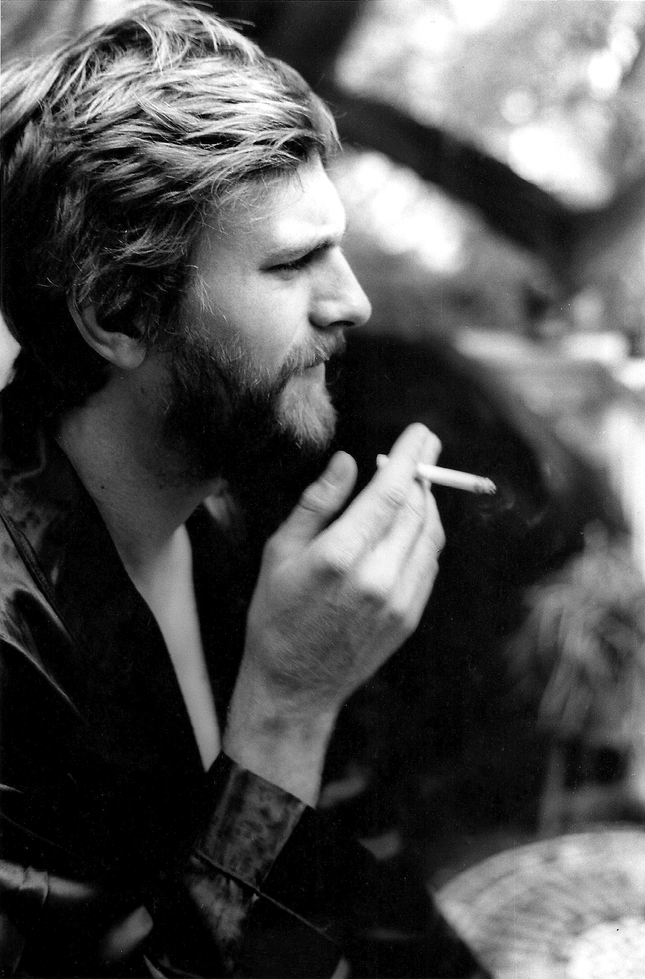 Pensive and troubled man holding a lit cigarette